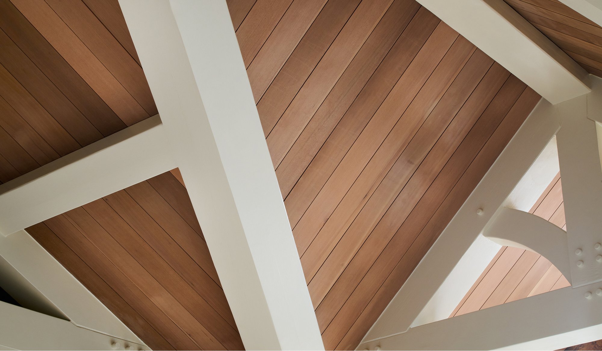 Close up photo of cathedral ceilings in a home featuring Timber Trading wood.  