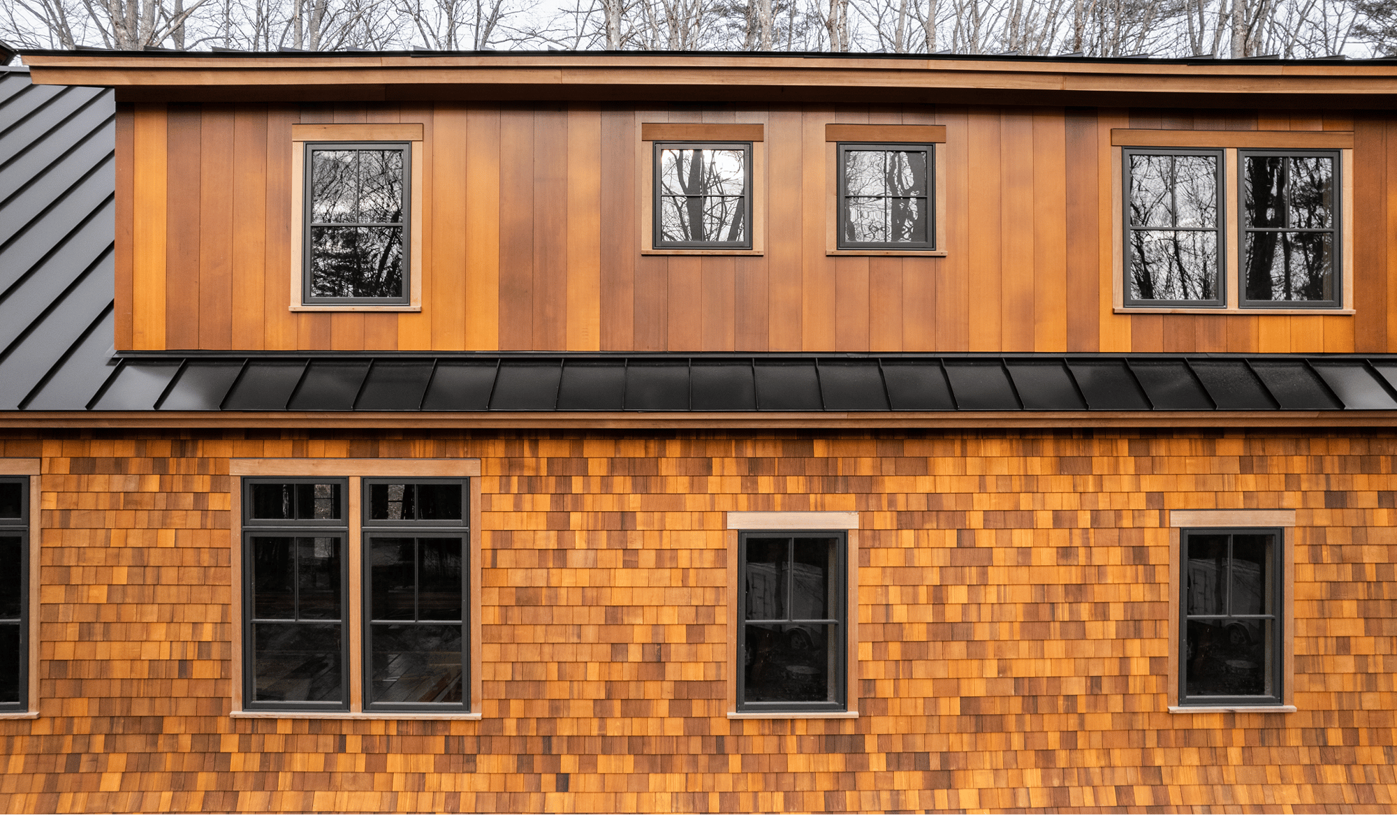 Wide exterior photo of a home on Squam Lake in Center Harbor, NH featuring Timber Trading ICON® thermally modified wood.  